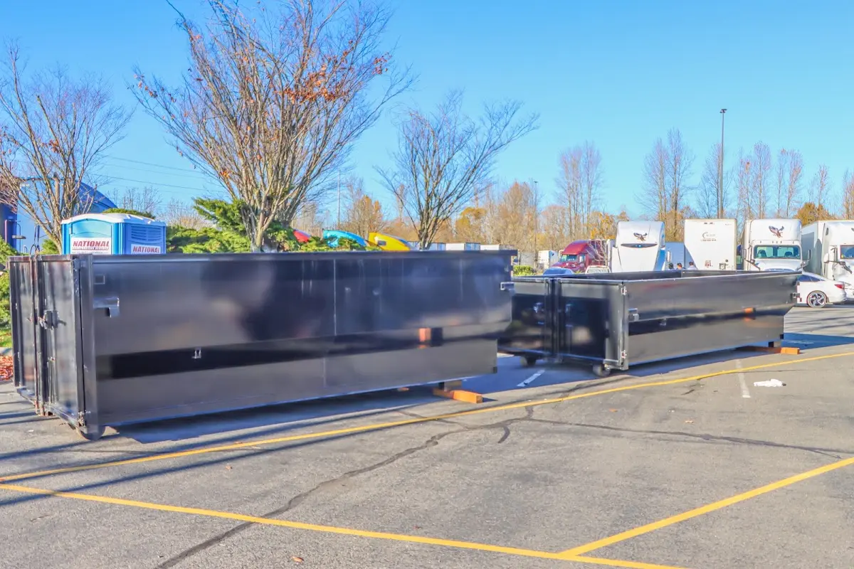 Professional dumpster rental service with roll-off container on residential driveway in Gateway